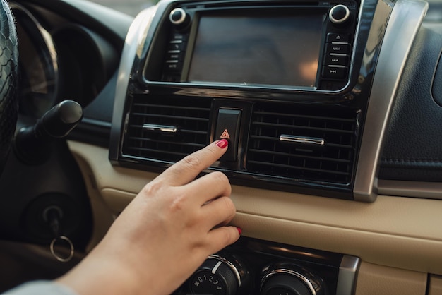 Pushing the car emergency button on car's dashboard, inside car.