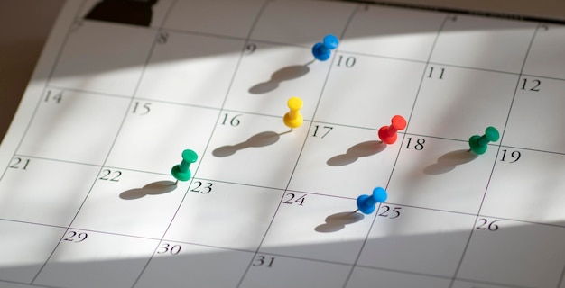 Pushpins or thumbtacks on calendar