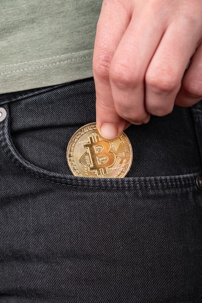 put btc coin in your pocket,buy invest in bitcoin closeup.