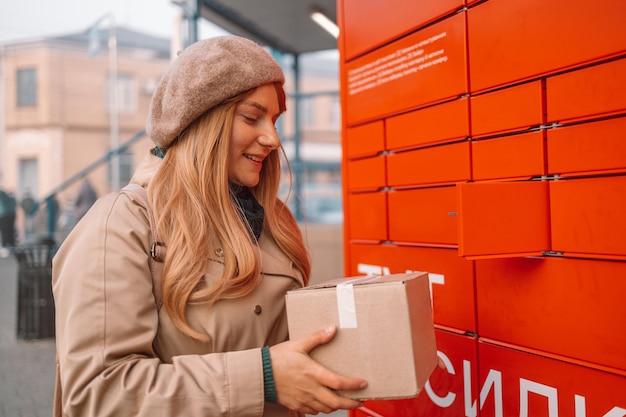 Putting carton box with shipping goods to self service postal case after online shopping mail