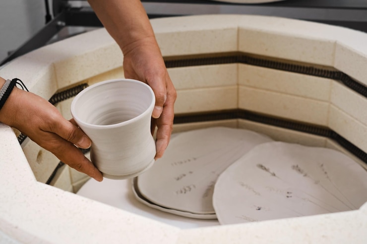 Photo putting clay ceramics to the kiln for firing