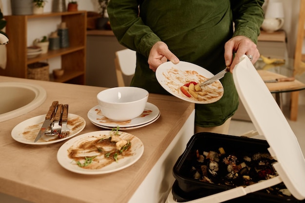 Putting leftovers of salad in trash bin