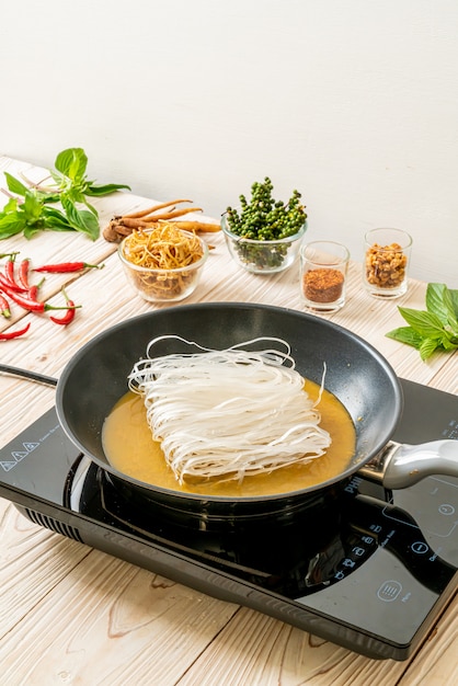 putting noodle on pan with sauce