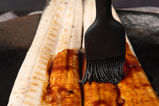 Photo putting sauce on the grilled eel