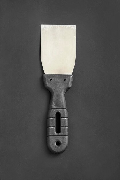 Putty knife on black background