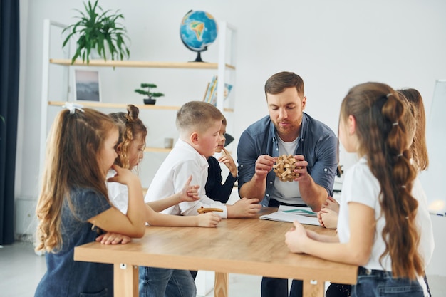 Puzzel speelgoed verkennen groep kinderen studenten in de klas op school met leraar