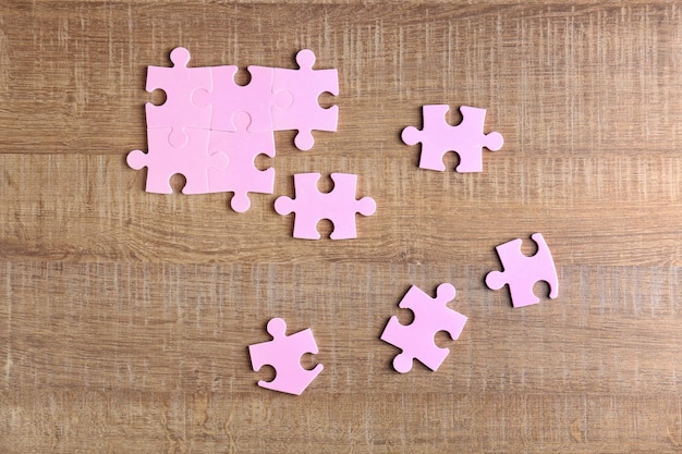 Puzzle pieces on wooden background Unity concept