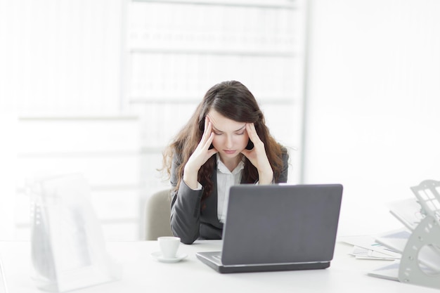 Puzzled businesswoman sitting behind a Desk