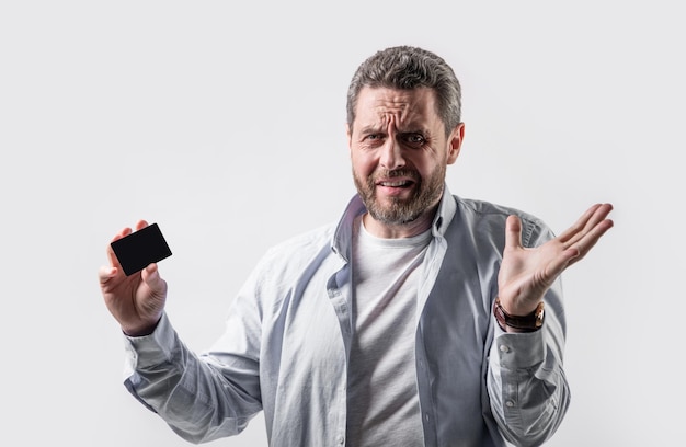 puzzled guy with business credit in studio guy holding business credit photo of guy hold business credit guy show business credit isolated on studio background