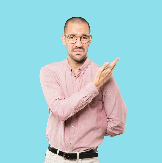 Puzzled young man doing a gesture of not understand