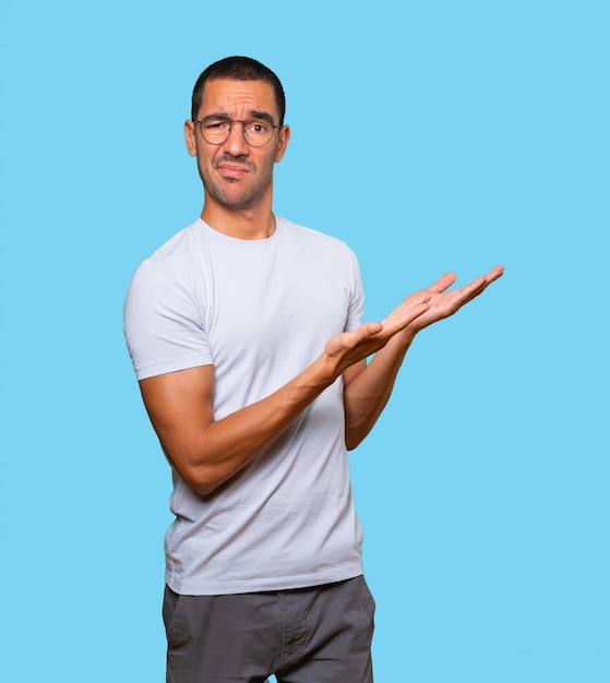 Puzzled young man doing a gesture of not understand