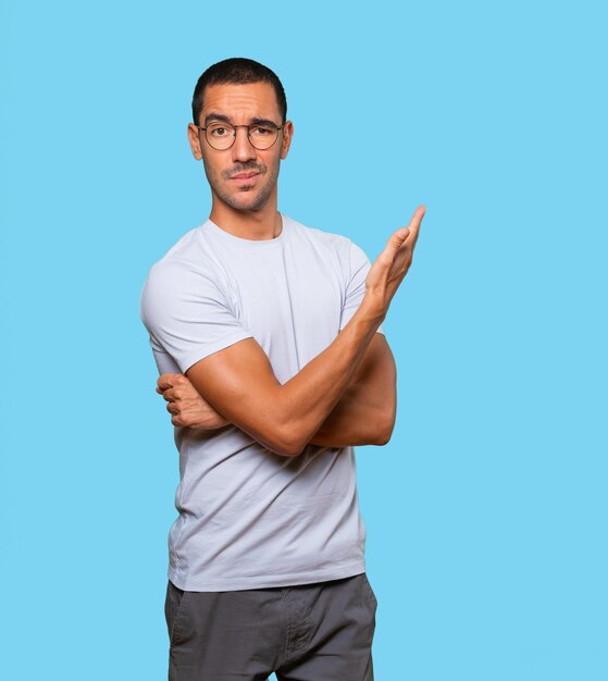 Puzzled young man doing a gesture of not understand