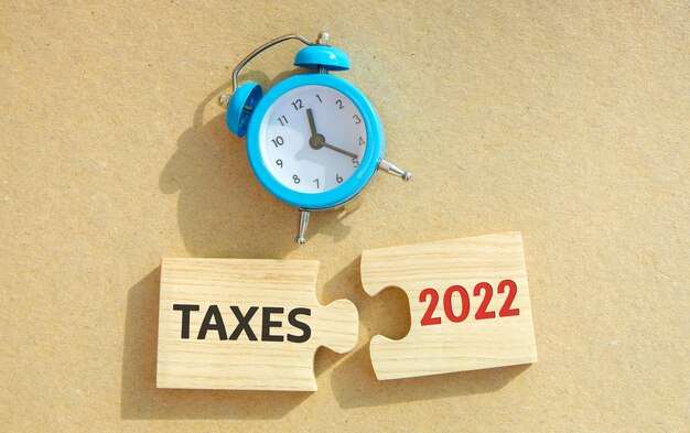 Puzzles with words tax 2022 and alarm clock The concept of paying the tax rate taxes burden