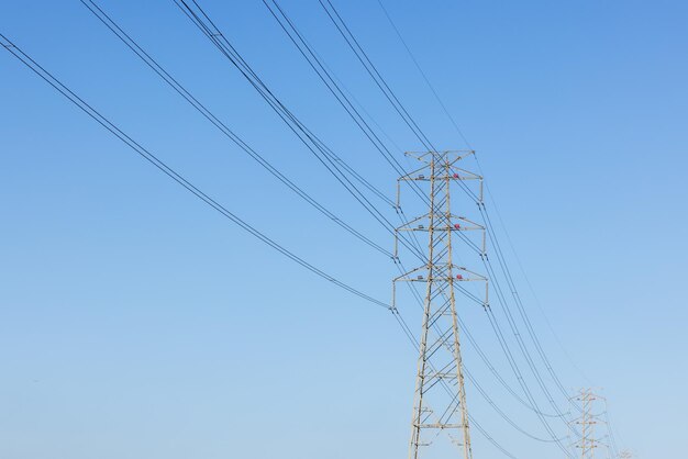 Пилон и высоковольтная линия электропередач над голубым небом