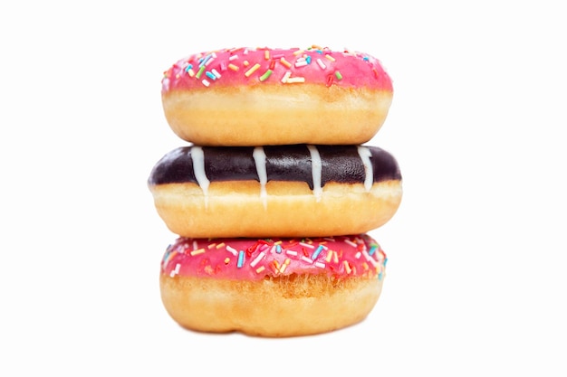 Pyramid of appetizing donuts with colorful icing Popular fast food Isolated on white background Closeup