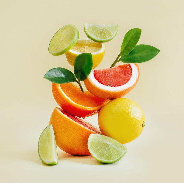 Pyramid of citrus fruits grapefruit, orange, lemon, lime on yellow