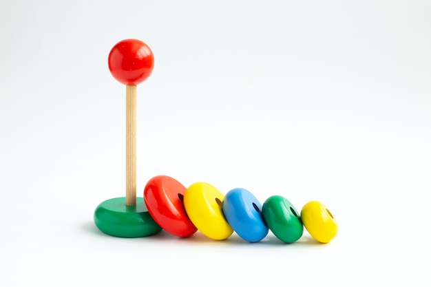 Pyramid from colored wooden rings on a white background. Kindergarten educational toys.