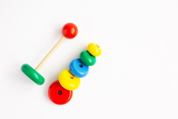 Pyramid from colored wooden rings on a white background. Kindergarten educational toys.