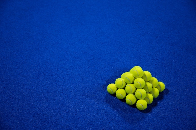 Pyramid of padel balls on the court