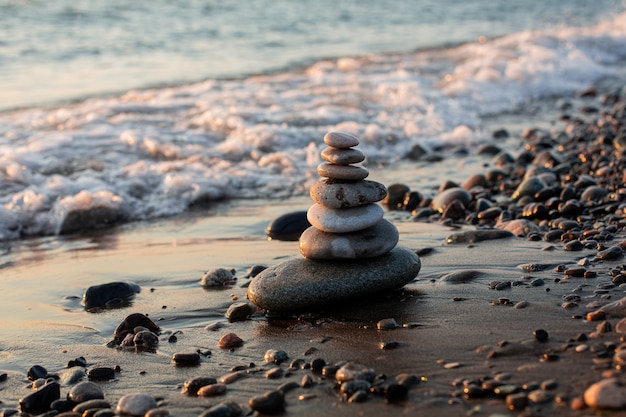 Photo pyramid of pebbles with water splashes on the beachwaves in background