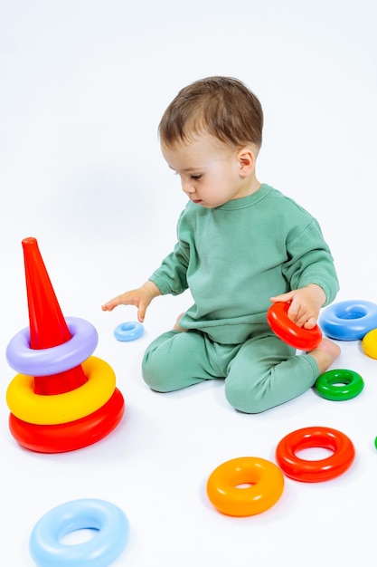 Pyramid playing small child Playful kid sitting with toys