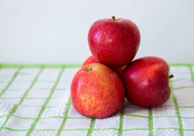 Pyramid of red apples with checkered tablecloth background