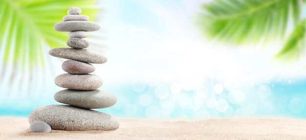 Photo pyramid of sea pebbles on a sunny sand beach