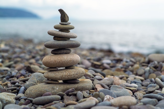 A pyramid of sea stones on the background of the sea.