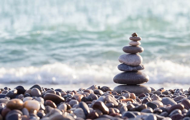 Pyramid of sea stones on pebbles of the sea shore