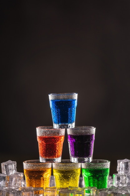 Pyramid of shots with colorful alcohol on ice