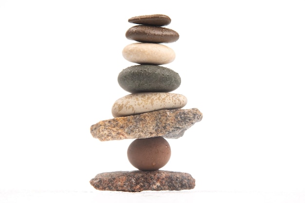 Пирамида из сложенных камней на белом фоне стабилизация и баланс в жизни
