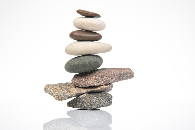 Foto piramide di pietre impilate su uno sfondo bianco stabilizzazione e equilibrio nella vita