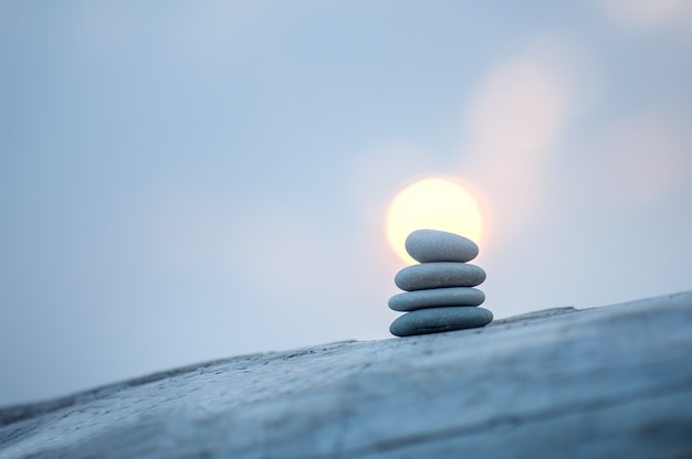 Photo pyramid of stones by the sea at dawn. balanced zen stones.