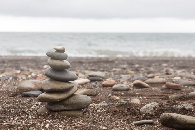 A pyramid of stones on the seashore copy space for your\
ads