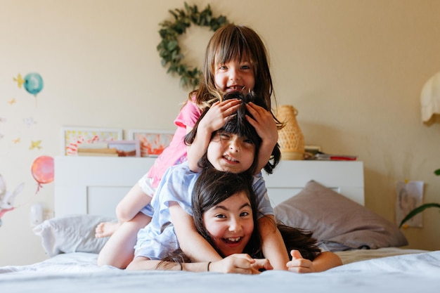 互いに横たわっている3人の笑顔の女の子のピラミッド