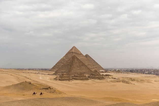 pyramids against cloudy sky