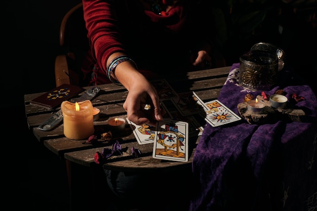 Pythoness reads tarot cards in a dark environment