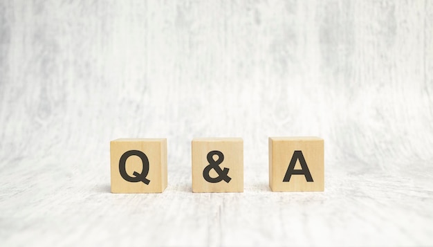 Q and a sign on wooden cubes on wooden background