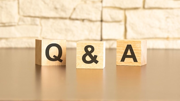 Q and A text from wooden blocks on a gray stone background QA is short for Question and Answer information concepts