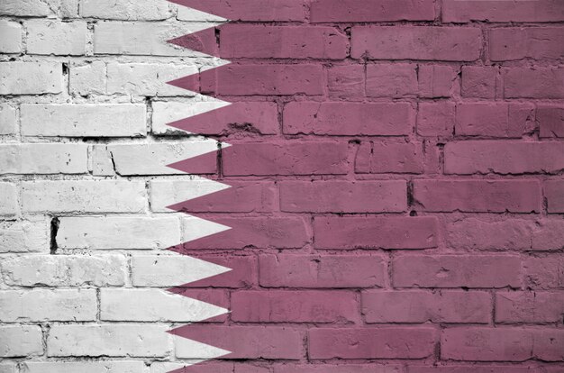 Qatar flag is painted onto an old brick wall