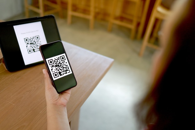 QR 코드 결제. E 지갑. QR 코드 온라인 쇼핑 현금없는 기술 개념을 스캔하는 여자