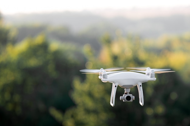 Quadcopter drone flying with a camera over a lake.