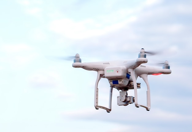 Quadcopter drone with the camera against the blue sky