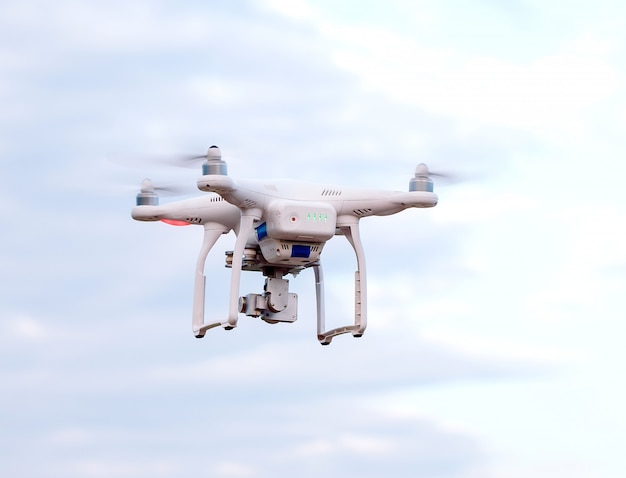 Quadcopter drone with the camera against the blue sky