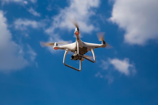 Quadcopter in flight against a blue sky