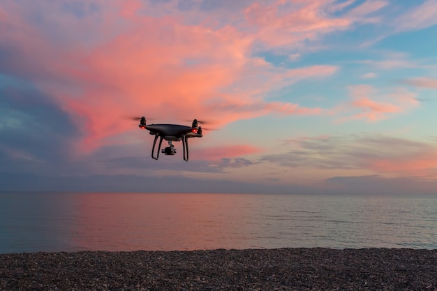 The quadrocopter in the air on the sunset background