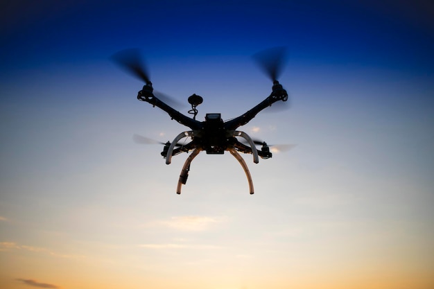 Quadrocopter in flight at sunset