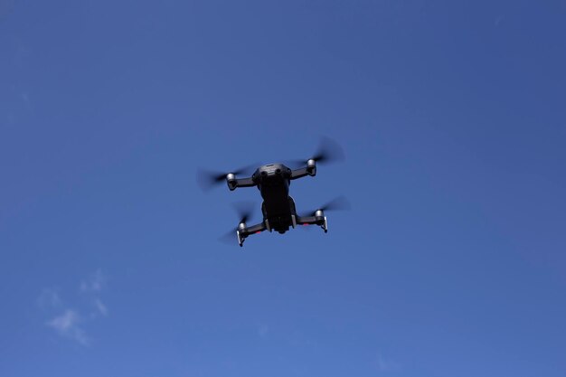 Quadrocopter met een professionele camera vliegt in de blauwe hemel