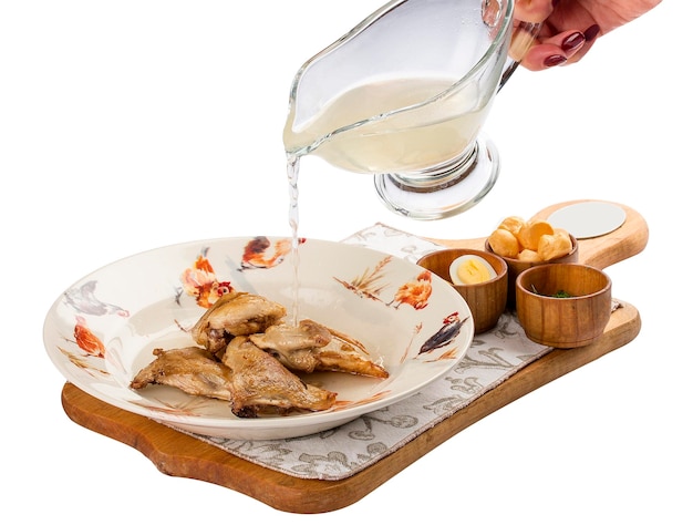 Quail broth with crackers and herbs on a wooden board On white background