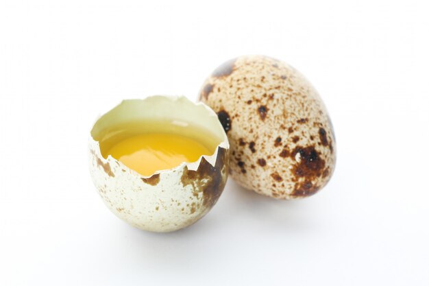 Quail egg and half yolk isolated on white